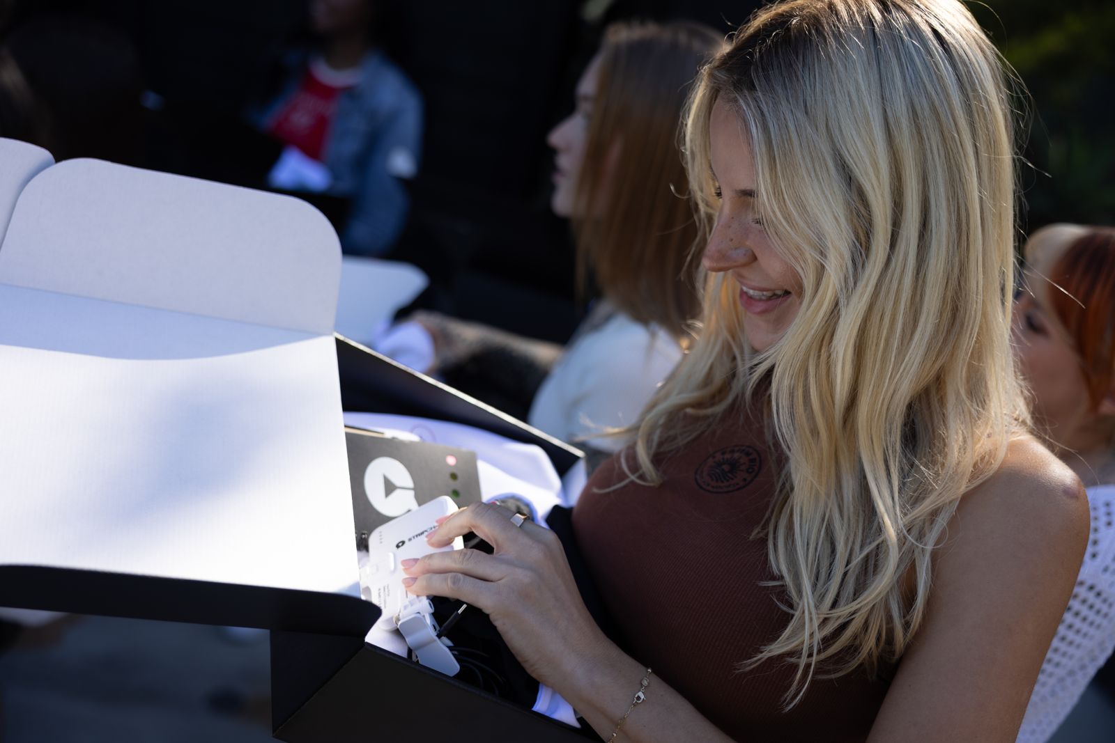 A cast member opens her SC House welcome box on arrival day