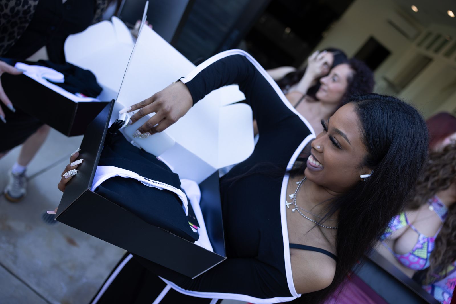 A cast member opens her SC House welcome box on arrival day