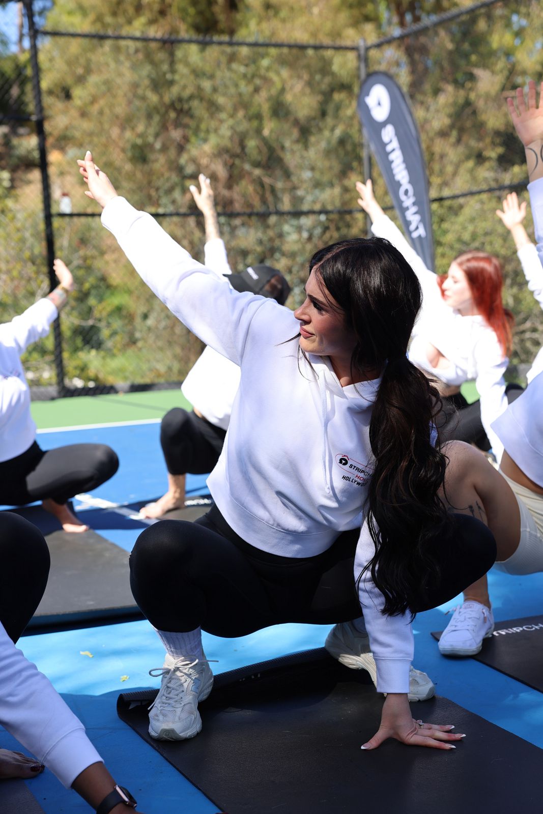Goat yoga session on the pickleball court at the SC House Hollywood, goats climbing on cast members' backs