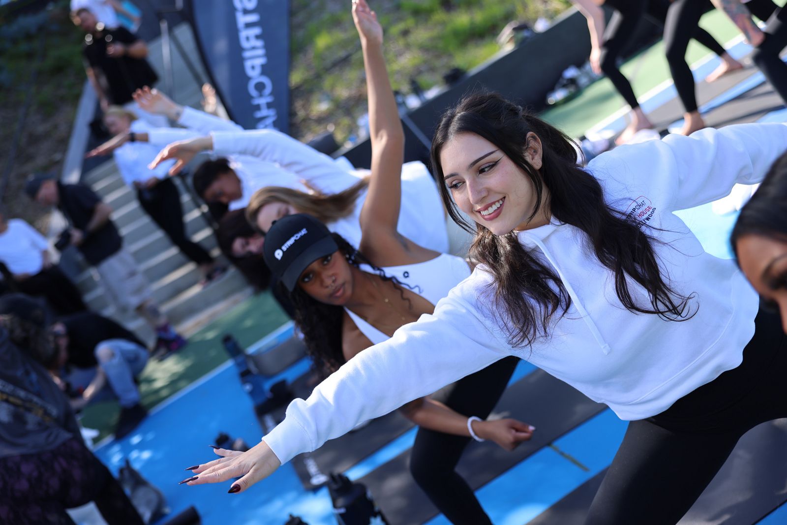 Goat yoga session on the pickleball court at the SC House Hollywood, goats climbing on cast members' backs