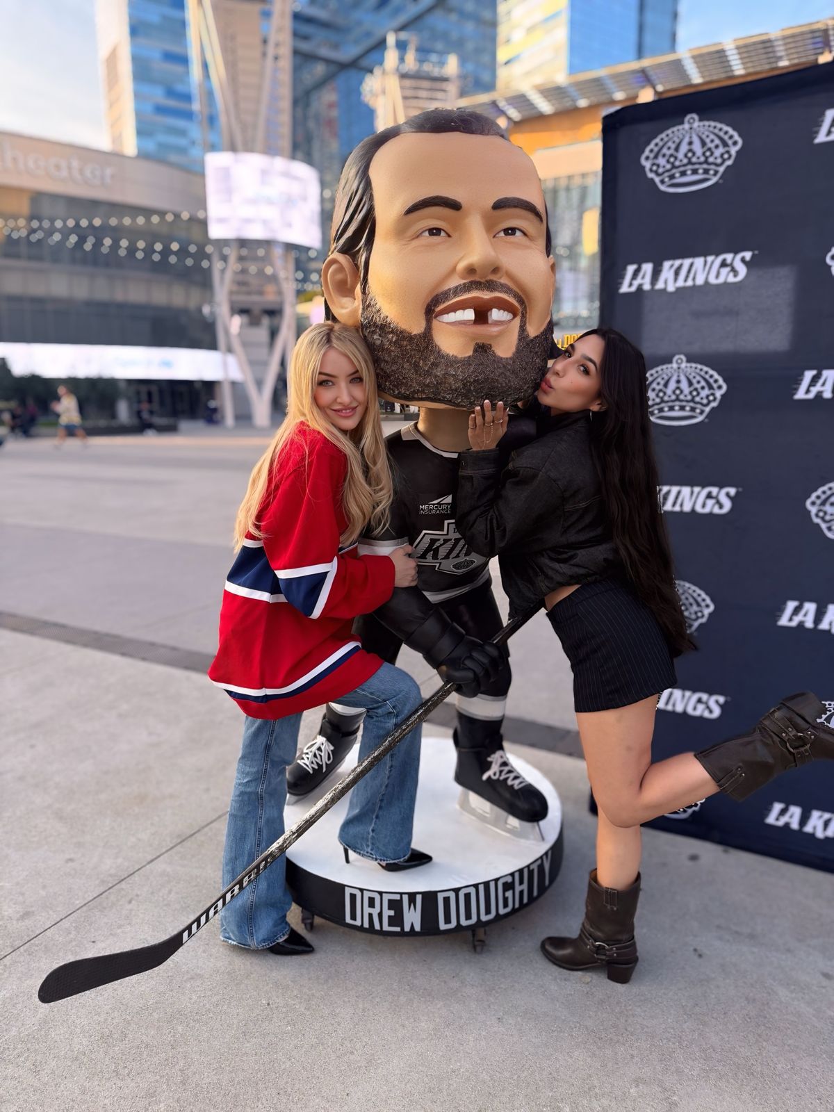 Cast members pose with a giant Drew Doughty bobblehead outside the LA Kings game